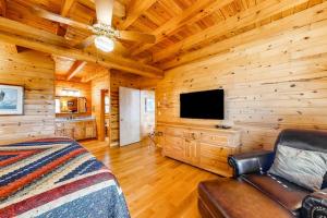 a bedroom with a bed and a television in a log cabin at Timberidge Lodge in Sylva +30 photos