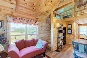 a living room with a pink couch and a window at Phobos Cabin in Mars Hill