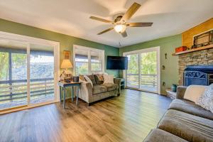a living room with a ceiling fan and a fireplace at Chipmunk Lane in Maggie Valley