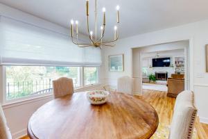a dining room with a wooden table and a chandelier at Blue Ridge Cottage in Waynesville