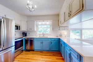 a kitchen with blue cabinets and a refrigerator at Blue Ridge Cottage in Waynesville