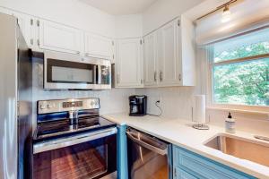 a kitchen with white cabinets and a stove top oven at Blue Ridge Cottage in Waynesville