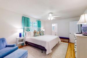 a bedroom with a white bed and a blue couch at Blue Ridge Cottage in Waynesville +15 photos
