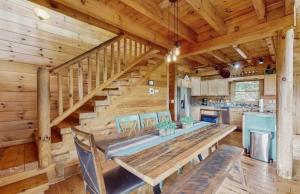 a dining room and kitchen with a large wooden table and stairs at 4 Bed 4 Bath Vacation home in Sylva in Sylva