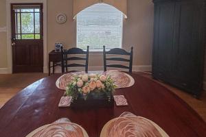a dining room table with a vase of flowers on it at Stone Cottage 1973 in Lake Junaluska +25 photos