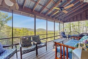 a screened in porch with chairs and a table at Merrywoode in Lake Toxaway