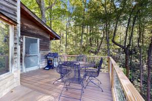 a patio with a table and chairs on a deck at Merrywoode in Lake Toxaway
