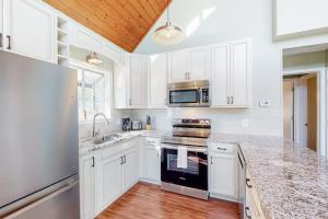 a kitchen with white cabinets and a stove top oven at Lake Emory Gem in Franklin