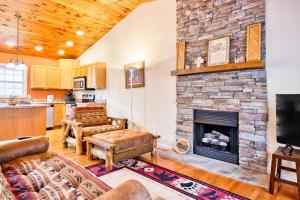 a living room with a large stone fireplace at Trimont Mountain Cottage in Franklin