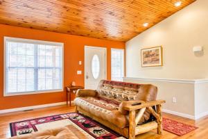 a living room with a leather couch and a wooden ceiling at Trimont Mountain Cottage in Franklin