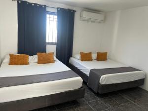 two beds in a room with blue curtains at Access Blue Cristalh in Monterrey