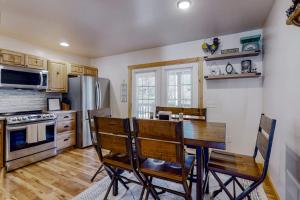 a kitchen with a table and chairs and a refrigerator at The Mountain Haven in Maggie Valley