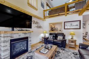 a living room with a fireplace and a flat screen tv at The Mountain Haven in Maggie Valley