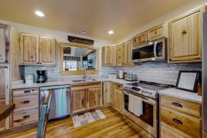 a large kitchen with wooden cabinets and wooden floors at The Mountain Haven in Maggie Valley +15 photos