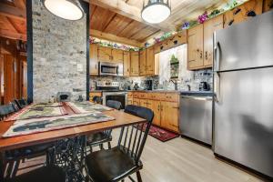 a kitchen with a table and a refrigerator at Black Bear Cabin Fox Mountain in Franklin