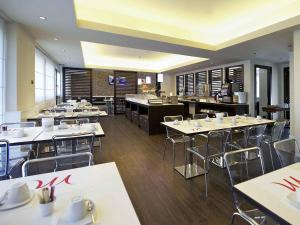 a restaurant with tables and chairs in a room at Mercure Bergamo Aeroporto in Stezzano