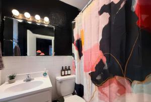 a bathroom with a sink and a toilet and a mirror at Fifa Walkable King Bed Full Kitchen Central Apartment in Philadelphia