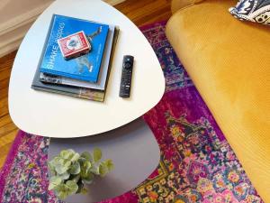 a white table with a book and a remote on a rug at Fifa Walkable King Bed Full Kitchen Central Apartment in Philadelphia
