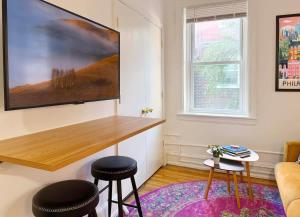 a living room with a table and two stools at Fifa Walkable King Bed Full Kitchen Central Apartment in Philadelphia