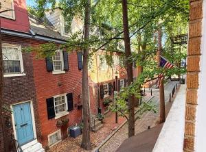 a brick building with a blue door on a street at Fifa Walkable King Bed Full Kitchen Central Apartment in Philadelphia +1 photo