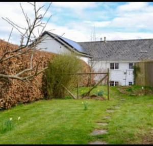 a white house with a fence in a yard at Bwthyn canol in Sennybridge +1 photo