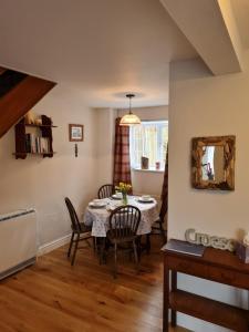 a dining room with a table and chairs and a mirror at Bwthyn canol in Sennybridge