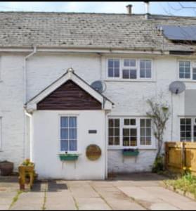 a white house with a large white garage at Bwthyn canol in Sennybridge