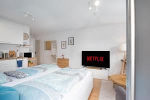a living room with two beds and a tv at Modernes Apartment mit Küche, Parkplatz, WLAN - Nähe Schwäbisch Gmünd in Waldstetten