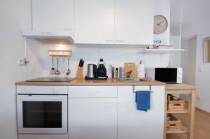 a kitchen with white cabinets and a sink at Modernes Apartment mit Küche, Parkplatz, WLAN - Nähe Schwäbisch Gmünd in Waldstetten +18 photos