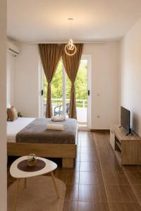 a bedroom with a bed and a tv and a table at Apartments Katana in Ulcinj