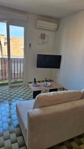 a living room with a couch and a flat screen tv at La casa de valras in Valras-Plage