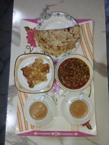 a tray with three bowls of food on a table at Hotel Multan Avenue Multan in Multan