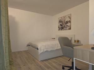 a bedroom with a bed and a desk and a chair at Duplex Rooftop premium - 4 chambres - Evry in Courcouronnes