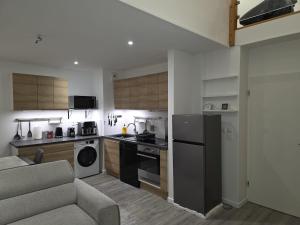 a kitchen with a stove and a couch in a room at Duplex Rooftop premium - 4 chambres - Evry in Courcouronnes