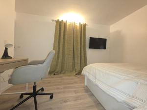 a bedroom with a bed and a desk and a chair at Duplex Rooftop premium - 4 chambres - Evry in Courcouronnes