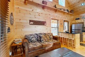 a living room with a leather couch in a cabin at Whispering Pines in Murphy