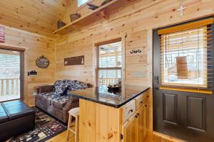 a log cabin with a kitchen and a living room at Whispering Pines in Murphy