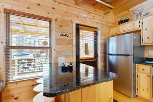 a kitchen with a refrigerator and a counter top at Whispering Pines in Murphy +10 photos