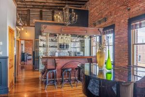 a kitchen with a bar and a brick wall at Brick Loft Penthouse on Main in Brevard