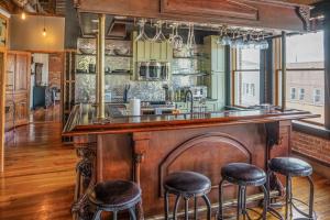 a kitchen with a large wooden bar with stools at Brick Loft Penthouse on Main in Brevard