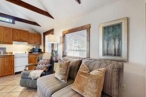 a living room with a couch and a kitchen at Main Street Wood Cottage in Brevard