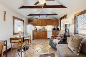 a living room with a couch and a table and a kitchen at Main Street Wood Cottage in Brevard