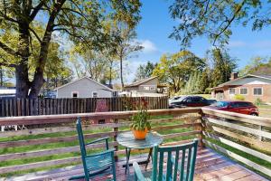 a table and chairs on a deck with a fence at Main Street Brick Cottage in Brevard