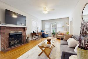 a living room with a couch and a fireplace at Main Street Brick Cottage in Brevard +15 photos
