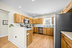 a kitchen with wooden cabinets and a refrigerator at Hominy Creek Haven in Candler +22 photos