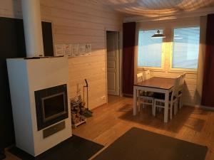 a living room with a table and a fireplace at Nilimella Camping & Resort in Sodankylä