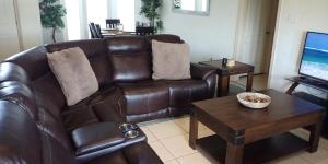 a living room with a brown leather couch and a table at Relaxing comfort house nice equiped in Pharr
