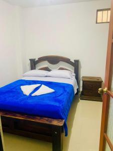 a bedroom with a bed with a blue comforter at Tu hogar en el Líbano Moderno Amplio y Central Parqueadero Privado y Gratis Hasta 8 huéspedes Descansa cerca del Nevado del Ruiz in Líbano