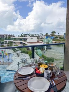 a table with plates of food on a balcony at Makia Beach Experience- Flat 202D in Ipojuca