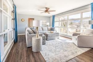 a living room with a couch and chairs and windows at The Willows in Waynesville